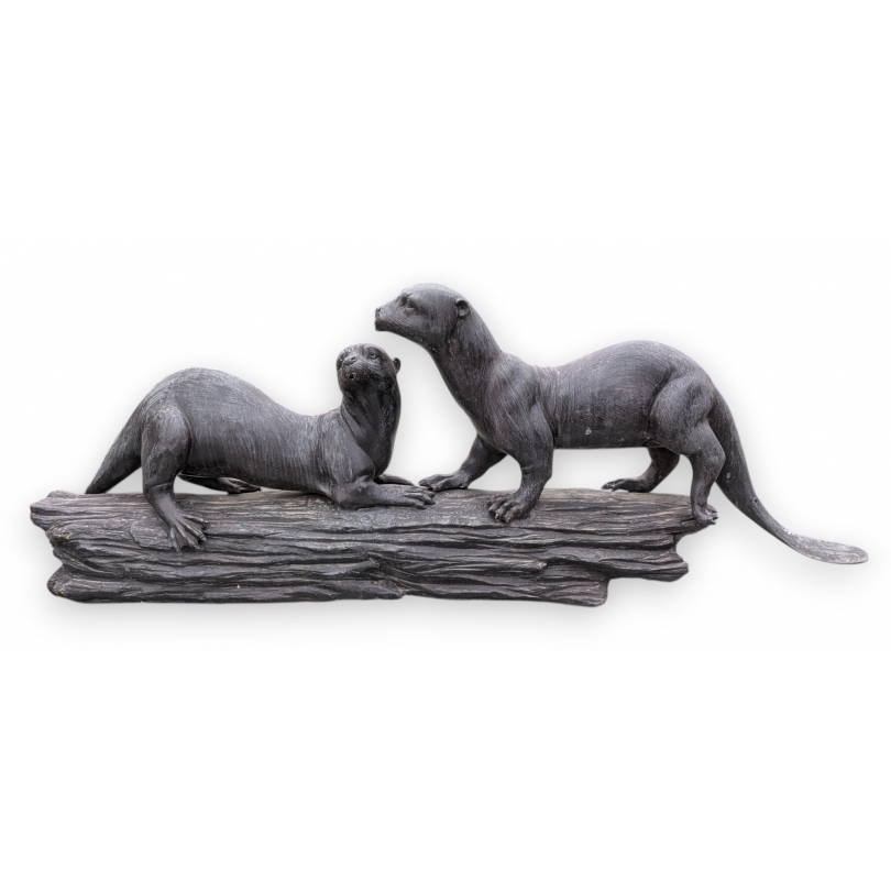 A pair of otters on a branch, cast in bronze