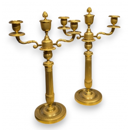 A pair of Empire-style candlesticks in gilded bronze