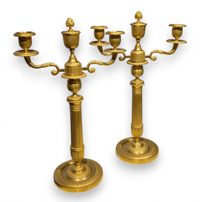 A pair of Empire-style candlesticks in gilded bronze