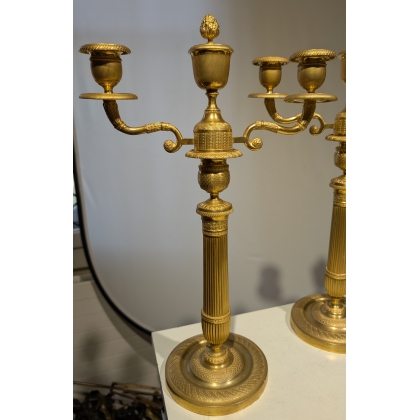 A pair of Empire-style candlesticks in gilded bronze