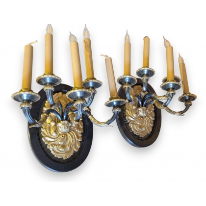 A pair of wall lights in gilded and blackened bronze