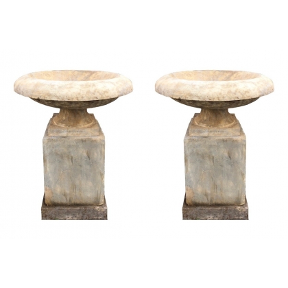 A pair of flared basins on stone plinths