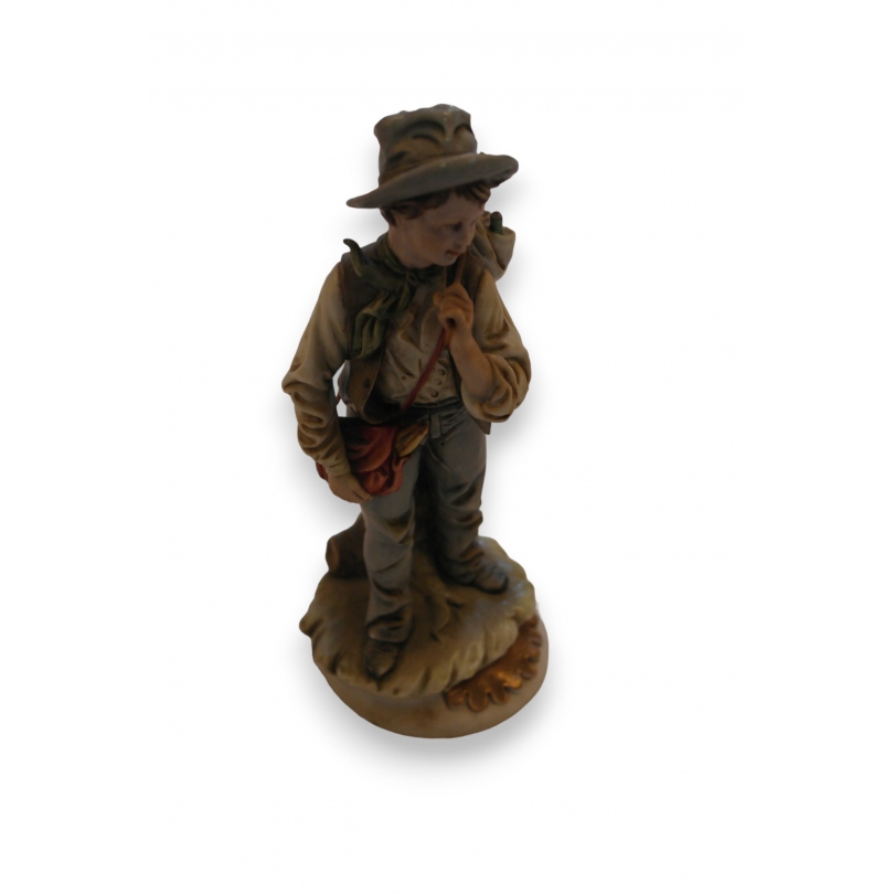 Porcelain statue of a boy by Capo, available from Moinat SA – Antiques and home décor