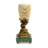Coquillage en porcelaine sur un dauphin en bronze
