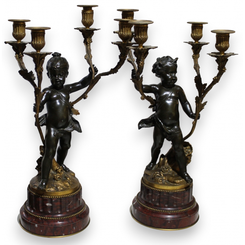 A pair of candlesticks depicting Cupids, signed L. GRÉGOIRE