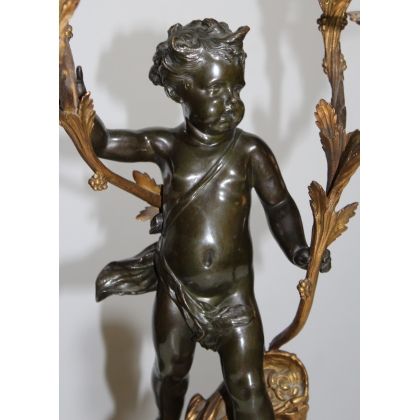 A pair of candlesticks depicting Cupids, signed L. GRÉGOIRE