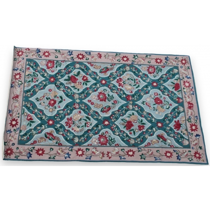 Arraiolos rug with a pink floral pattern on a turquoise background