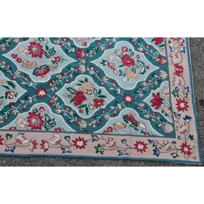 Tapis Arraiolos décor fleurs rose fond turquoise