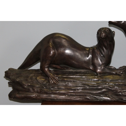 A pair of otters on a branch, cast in bronze