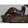 A pair of otters on a branch, cast in bronze