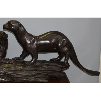 A pair of otters on a branch, cast in bronze