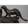 A pair of otters on a branch, cast in bronze