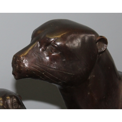 A pair of otters on a branch, cast in bronze