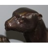 A pair of otters on a branch, cast in bronze