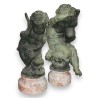Pair of bronze putti on marble plinths