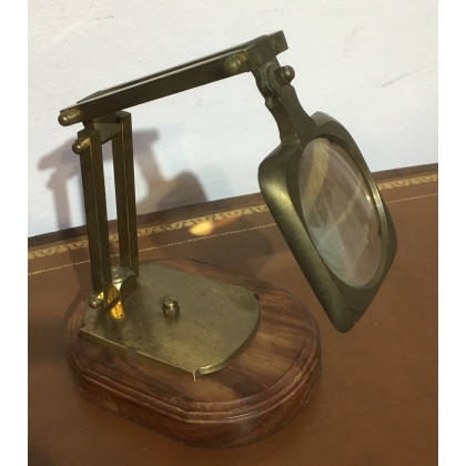 Loupe articulée en laiton sur un socle en bois