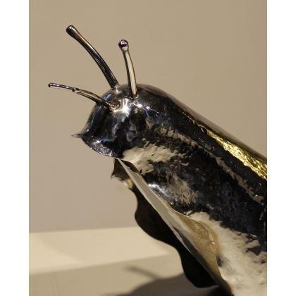 A snail made of chrome-plated and polished brass, shaped like a box