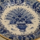 Plat rond décor au paon en faïence de Delft