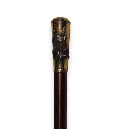 A walking stick with a gilded silver pommel adorned with a peony