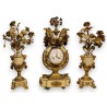 A clock and two candlesticks made of beige and bronze-coloured sheet metal