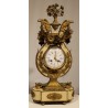 A clock and two candlesticks made of beige and bronze-coloured sheet metal