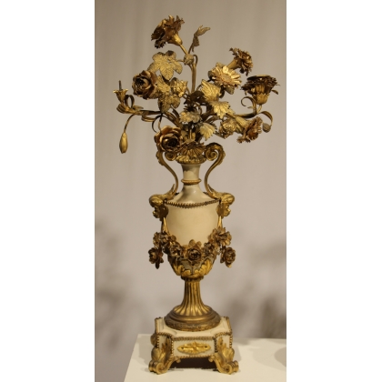 A clock and two candlesticks made of beige and bronze-coloured sheet metal