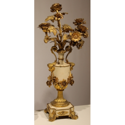 A clock and two candlesticks made of beige and bronze-coloured sheet metal
