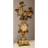 A clock and two candlesticks made of beige and bronze-coloured sheet metal