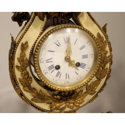 A clock and two candlesticks made of beige and bronze-coloured sheet metal