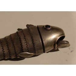 Poisson articulé en argent, yeux rouges