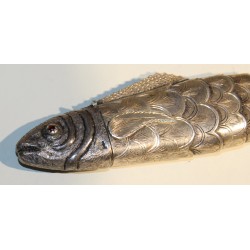 Poisson articulé en argent, yeux rouges