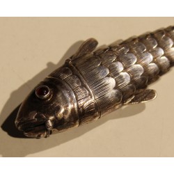 Poisson articulé en argent, yeux rouges