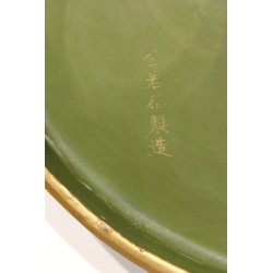 Round dish in green lacquer with a gold border, signed